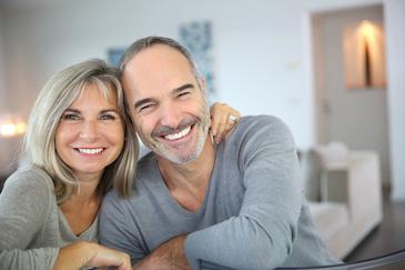 middle aged man and woman smiling in living room in North york on