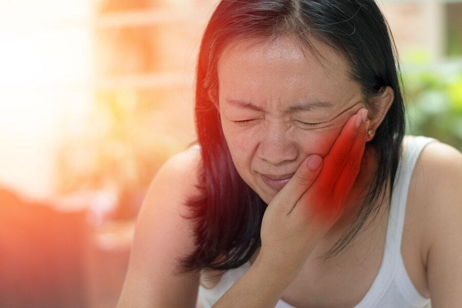 woman holding jaw from tooth pain during an emergency in north york