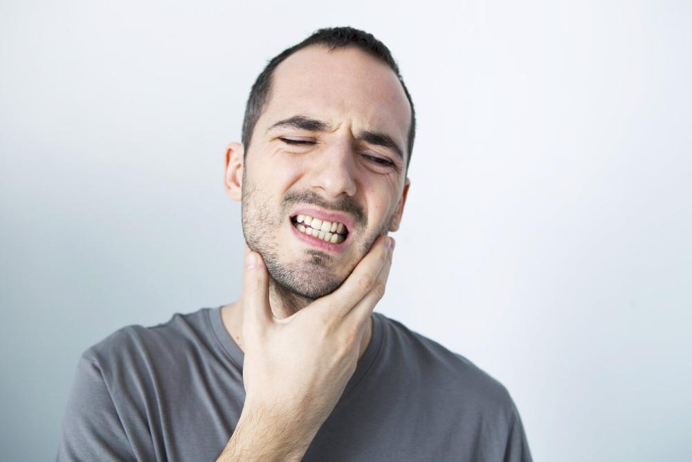 man holding jaw from TMJ pain