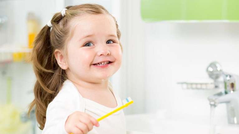 small girl brushing her teeth