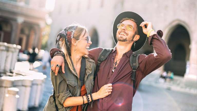 man and woman smiling while traveling 