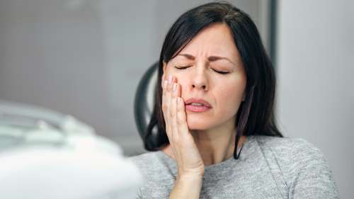 north york woman holding her jaw from TMJ pain