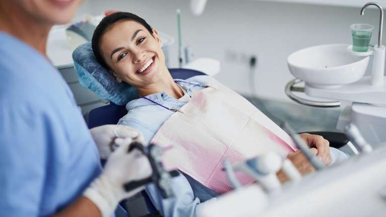 woman smiling in dental chair during cleaning in north york