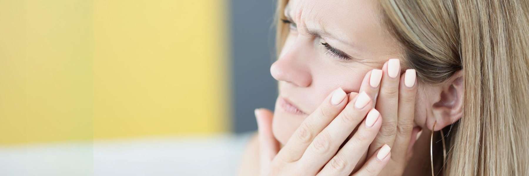 north york woman holding jaw from infected tooth pain