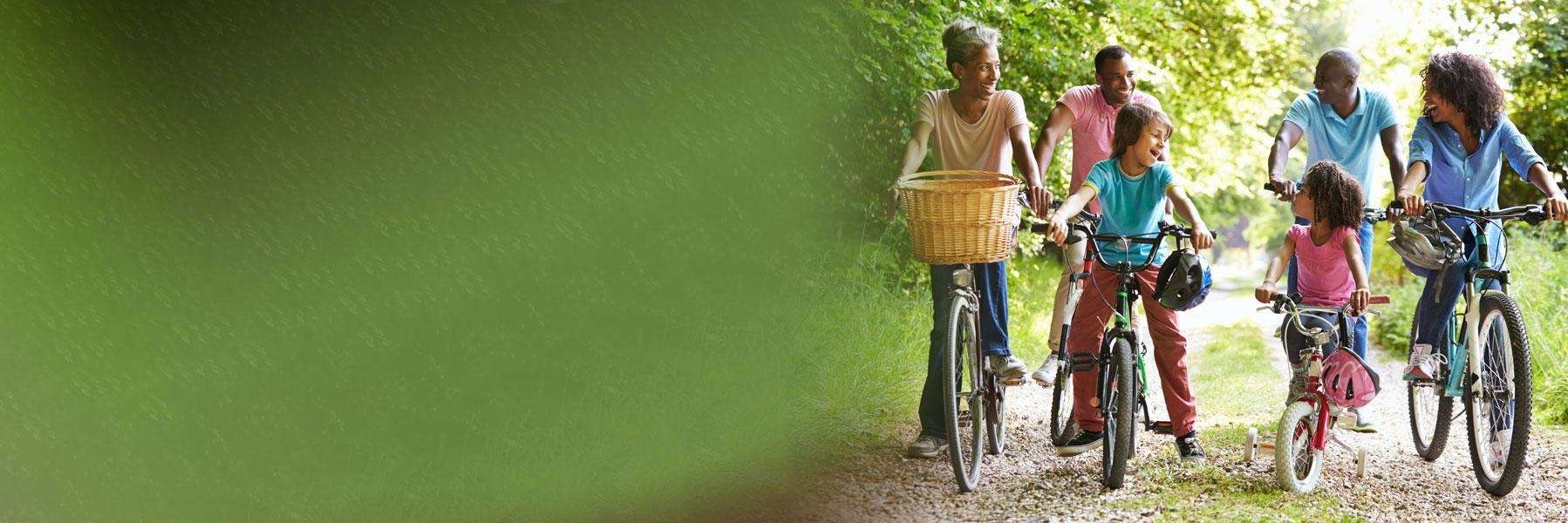 family riding bikes on a path in a north york park